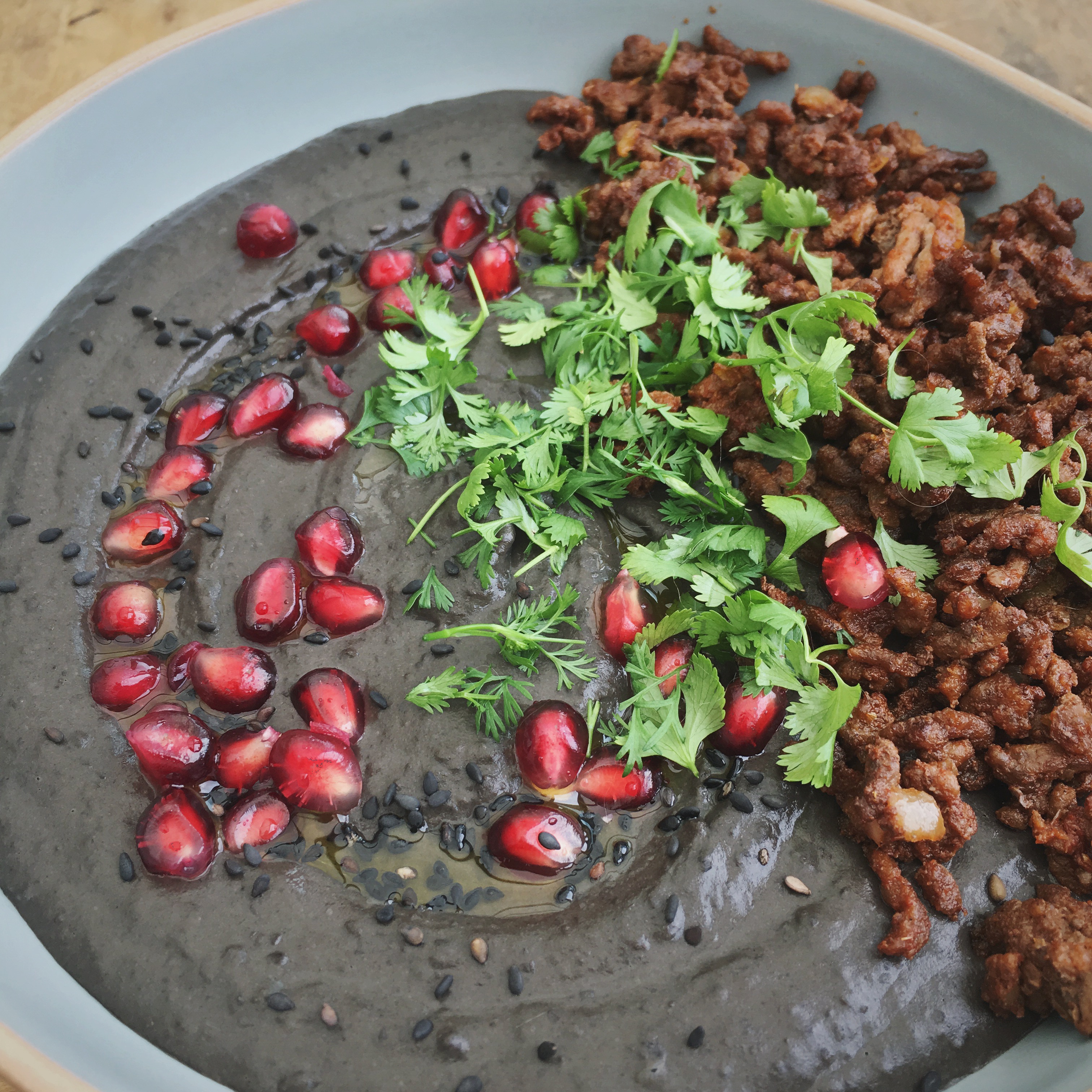 Zwarte bonen hummus met gekruid gehakt